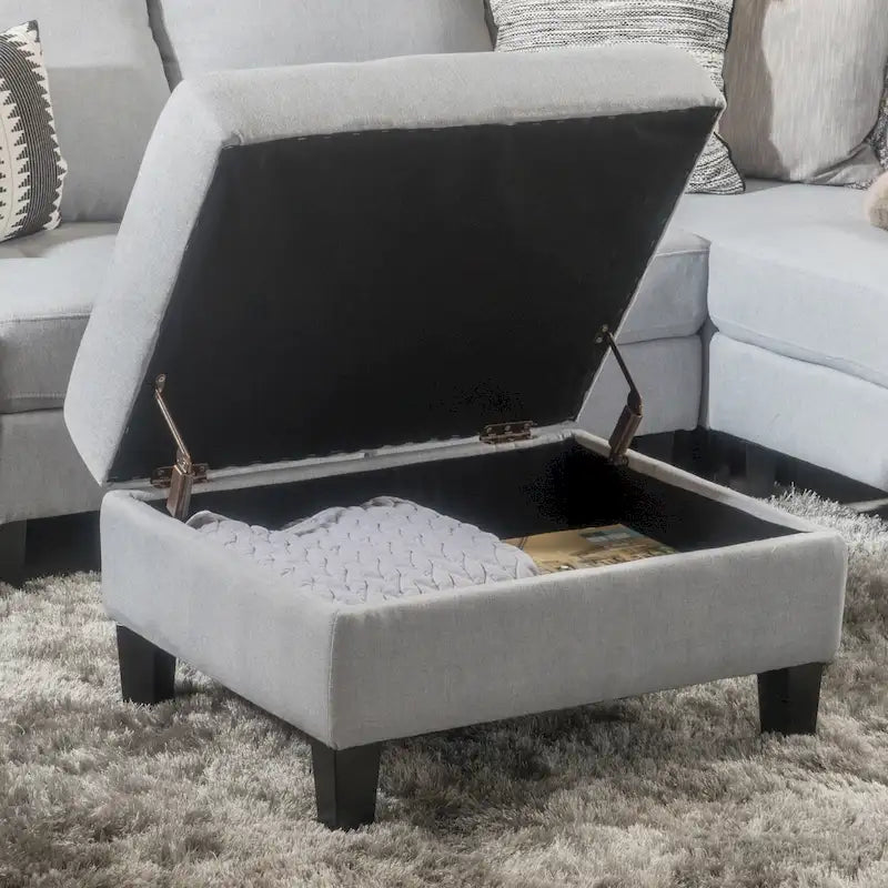 Otomano tapizado acolchado de almacenamiento de color gris claro con patas de madera de abedul